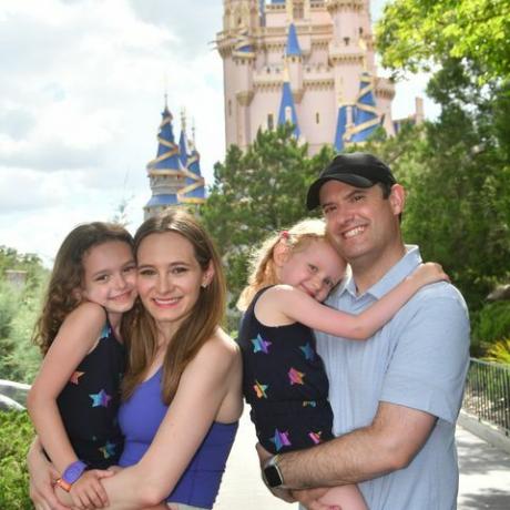 Eine Familie, die vor dem Cinderella-Schloss im Magic Kingdom Park lächelt