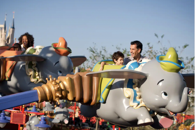 Passagiere, die Dumbo, den fliegenden Elefanten, im Magic Kingdom Park von Walt Disney World reiten