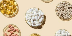 Verschiedene Pillen und Kapseln, Vitamine und Nahrungsergänzungsmittel in Petrischalen auf beigem Hintergrund