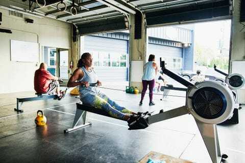 afroamerikaner auf rudergerät während des trainings im fitnessstudio